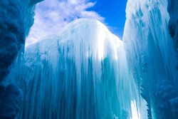 A beautiful view of huge ice formations against the blue sky with floating white clouds