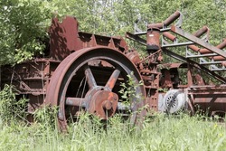 A pile of rusty junk and old mining equipment stored and lost in the nature