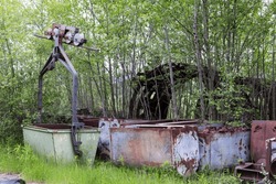 A pile of rusty junk and old mining equipment stored and lost in the nature