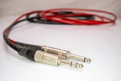 The one quarter inch stereo and mono audio cords on a white background