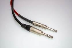 The one-quarter-inch stereo and mono audio cords on a white background