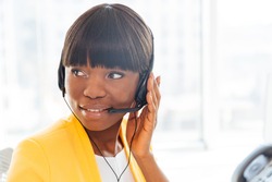 Happy afro american businesswoman working in call center and looking away