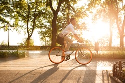 Image of young african man early morning with bicycle walking outdoors. Looking aside.