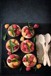 Delicious summer tartlets with raspberries and yoghurt. Yellow and red raspberries. Healthy dessert. Keto dessert.