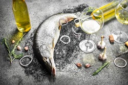 Fresh unprepared pike with white wine. On a rustic background.