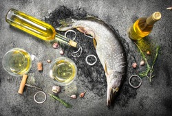 Fresh unprepared pike with white wine. On a rustic background.