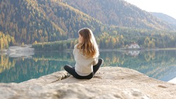 Girl sitting by mountain lake alpine area outdoors austria blue reflection forest beautiful view sunshine meditation selfcare mindfulness
