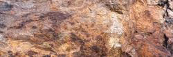 Rusted granite texture. Rusted stone background. Granite rocks. Colorful Old Cracked Rusty Rough texture. Rock wall backdrop with rough red brown texture. Grunge Abstract Stone Surface.