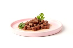Delicious wet food for a cat or dog, pieces of nutritious meat for an animal, dog or cat in a plate on a white background.