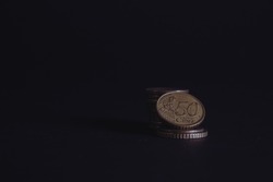 50 Euro cents on a black background. A fifty cent coin stands beautiful wallpaper money