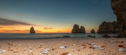 Coastal dreams - amazing beach with rocks and shells at sunrise. Do camilo beach algarve portugal