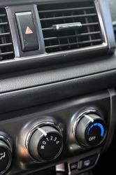 Thermostat and air conditioner fan speed dial on a car dashboard.