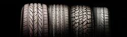 four new car tires in a row for passenger cars and crossovers. for different seasons, for autumn, summer, and mud all-season. long panorama layout