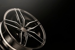 New black shiny alloy wheels rim. light from above, copyspace.