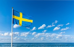 Swedish flag in the wind against a blue sky