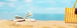Book on sandy beach with beach chair
