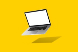 laptop floating in front of a yellow background