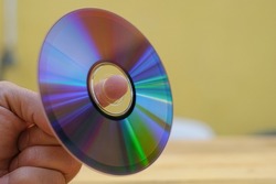 Man hand hold an used cd-rom disk, data storage device technology