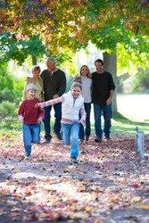 Multi-generation family walking through autumn park