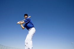 Baseball batter, in blue uniform, preparing to hit ball during competitive game, front view, low angle view (tilt)