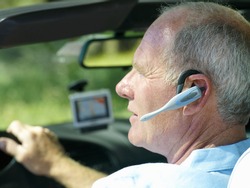 Man with hands-free device in car, side view