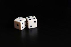 Two dice in a black background.