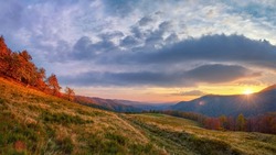 Beautiful sunset in the mountains, picturesque landscape in a mountain valley. The sun goes down behind the mountain range. Golden autumn in the Ukrainian Carpathians