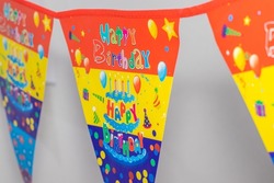 close-up photo of happy birthday flags,with inscription,hang in house,wall background. happy birthday in quarantine, pandemic,at home
concept: isolation,celebration with family.