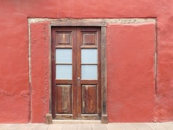 Traditional colonial house with red facade and wooden door. Historic town of Garachico. Tenerife Island. Canary Islands. Spain.  