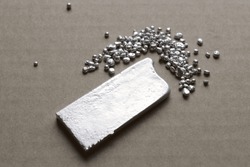 Precious metal smelted into a silver ingot, grains of 925 sterling silver 925 nearby. An essential foor jewelry making, and a reference on financial market.
