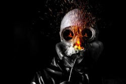 Man in the gas mask holding a burning flower. Radiation influence. Environmental pollution. Chernobyl concept. Dangerous nuclear power.