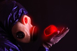 Man in the gas mask holding radioactive luminous apple. Radiation influence. Environmental pollution. Chernobyl concept. Dangerous nuclear power.