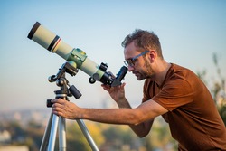 Amateur astronomer looking at the sky with a telescope.