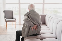 Senior old elderly man grandfather touching his back, suffering from backpain, sciatica, sedentary lifestyle concept. Spine health problems. Healthcare, insurance