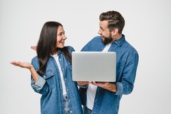 Impressed surprised caucasian young couple spouses wife and husband using laptop for online meeting, remote work, watching webinars, e-learning, playing games isolated in white