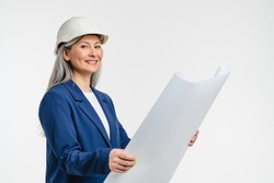 Happy mature middle-aged engineer architect foreman construction worker in white hard hat holding architectural plan, preparing for building designing a house, real estate agent isolated in white