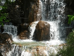 The waterfall flows down a stepped rocky area.
