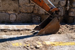 Excavators dipper or stick digging in a road to fix same pipeline.