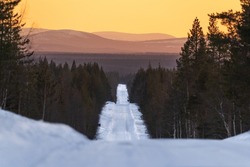 Icy and empty road in Finnish taiga forest.