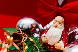 antique wooden figurine of santa claus between christmas balls and lights. christmas greeting card