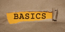 The word Basics appearing behind torn brown paper. Education concept.