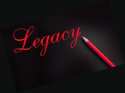 Legacy Word, written with yellow crayon pencil on black paper. Inheritance real estate last will concept.