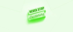 Never stop dreaming words printed on wooden blocks on soft pink. Positive thinking mindset concept