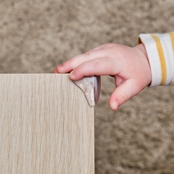 Danger for baby hit the corner of the table. Protect children from home furniture, kids safety
