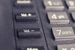 Button with text volume and mute on a landline phone in the office, close-up