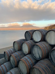 Whisky barrels with he paps of Jura as a background, outside the Bunnahabin Distillery on the island of Islay, the west coast of Scotland.