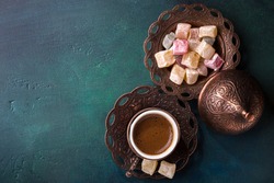 Traditional turkish coffee  and turkish delight on dark green wooden background. Flat lay.