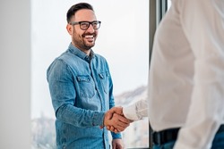 Businessman greeting job applicant businessmen handshaking over signed contract handsome entrepreneur handshake with a colleague cheerful young manager handshake with new employee getting a deal done