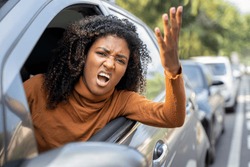 Aggressive woman driving car shouting at someone