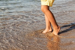 Sea Barefoot Sand Beach Background. Child Legs in Water. Sea Children Holiday .